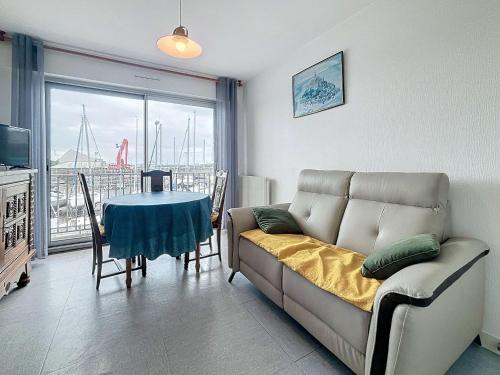 un salon avec un canapé et une table dans l'établissement Appartement au centre de Granville avec balcon, à 300m de la plage et du casino - FR-1-361-119, à Granville