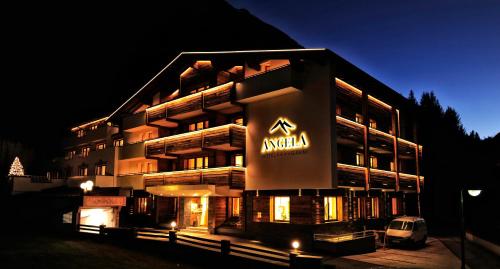 a large building with a sign on it at night at Hotel Garni Angela in Ischgl