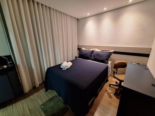 ein Schlafzimmer mit einem Bett, einem Schreibtisch und einem Stuhl in der Unterkunft Flat de luxo em Lagoa Santa in Lagoa Santa