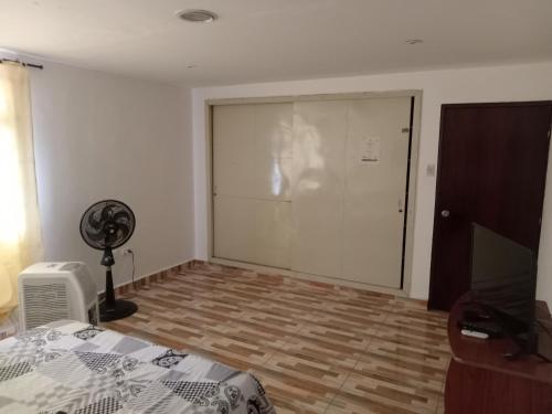 a bedroom with a bed and a door with a fan at Linda casa vacacional Andy-Santiago de Cali in Cali