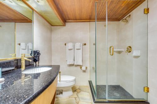a bathroom with a glass shower and a toilet at Castle Bamboo Waikīkī Hotel in Honolulu