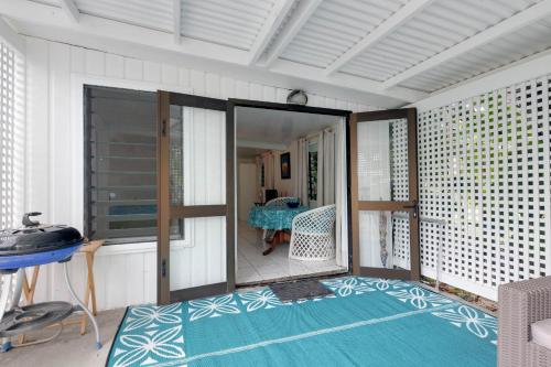 a screened in porch with a blue and white rug at Vaka Beach Cottage with AC Unlimited Wifi in Rarotonga