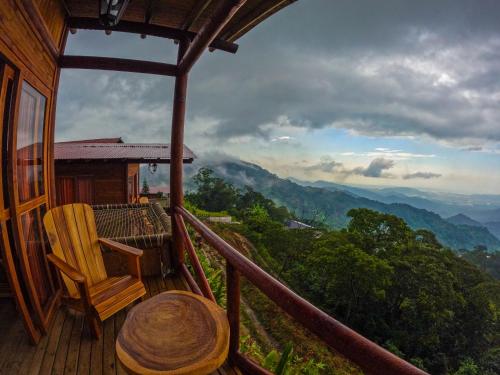 a balcony of a house with a table and chairs at Loma Nevada Minca Hotel in Minca