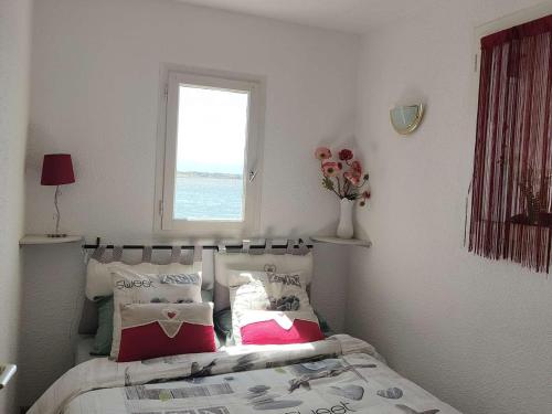 une chambre avec un lit avec des oreillers et une fenêtre dans l'établissement Appartement T2 - 4 pers. avec terrasse et piscine à Le Barcarès - FR-1-195-108, au Barcarès