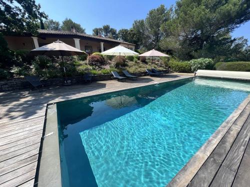 une piscine avec chaises et parasols dans une cour dans l'établissement Villa 4 chambres avec piscine privée dans la verdure - FR-1-726-36, à Gassin
