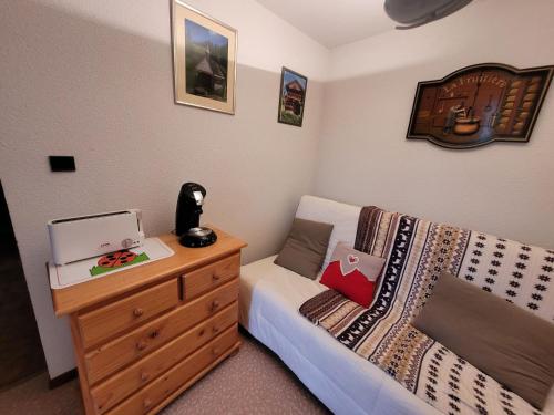 - une chambre avec un lit et une commode avec un ordinateur portable dans l'établissement Appartement 2P 4 couchages, balcon, parking, animaux admis à Châtel - FR-1-676-191, à Châtel