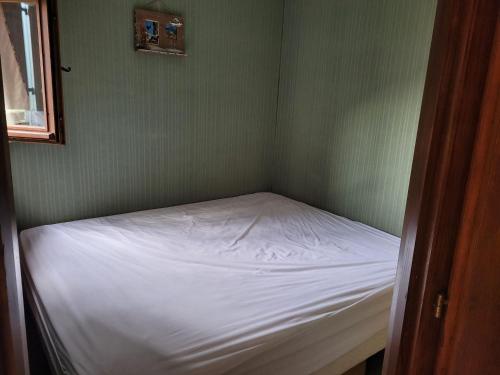 une petite chambre avec un lit blanc dans un mur vert dans l'établissement Appartement 2P 4 couchages, balcon, parking, animaux admis à Châtel - FR-1-676-191, à Châtel