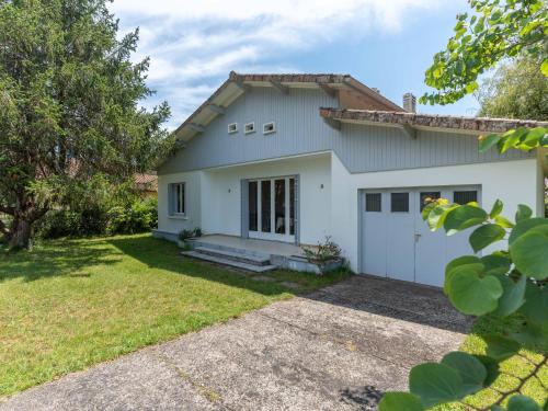 une maison avec un garage et une cour dans l'établissement Maison de vacances près du lac d’Aureilhan à 3 km de Mimizan, pour 6 pers. avec grand jardin clôturé - FR-1-50-139, à Aureilhan