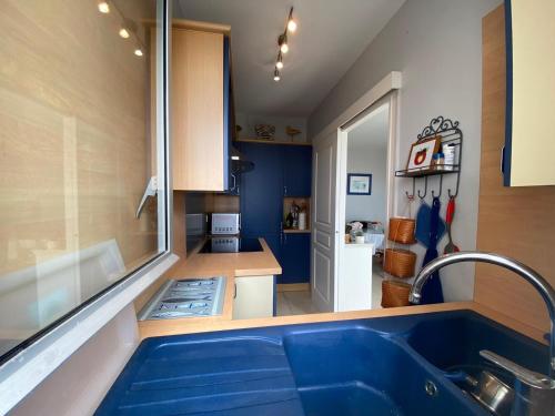 - une cuisine avec une grande baignoire bleue dans une chambre dans l'établissement Appartement cosy face mer, avec terrasse et parking - Saint-Jean-de-Monts, secteur Casino - FR-1-323-550, à Saint-Jean-de-Monts