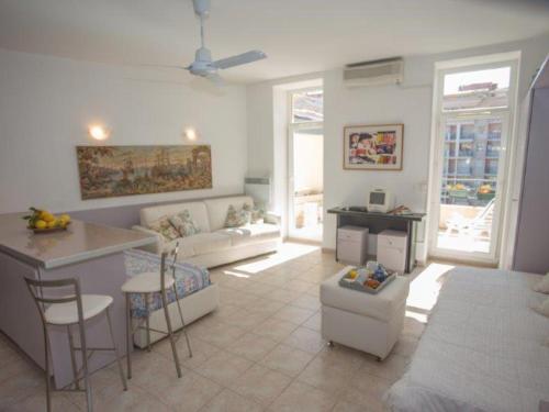 une cuisine et un salon avec un canapé et une table dans l'établissement Studio climatisé en centre-ville, proche plages, avec grande terrasse au calme - FR-1-196-362, à Menton