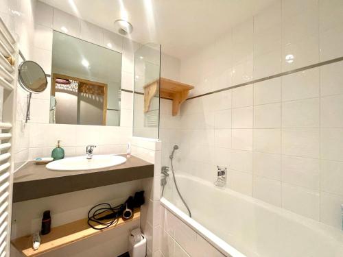 a bathroom with a sink and a tub and a mirror at Duplex de Charme pour 6 Personnes, Proche Centre et Pistes de Ski - FR-1-505-209 in Notre-Dame-de-Bellecombe