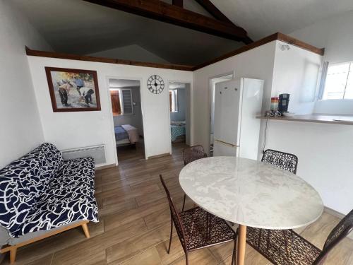 une cuisine et une salle à manger avec une table et des chaises dans l'établissement Chalet de 2 chambres à Gruissan - Terrasse, cuisine équipée, proche de la plage - FR-1-784-31, à Gruissan