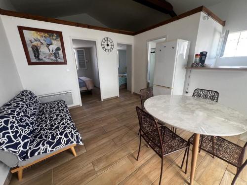 une cuisine et une salle à manger avec une table et des chaises dans l'établissement Chalet de 2 chambres à Gruissan - Terrasse, cuisine équipée, proche de la plage - FR-1-784-31, à Gruissan