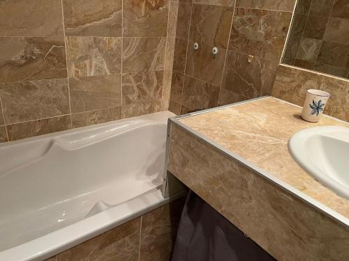 une salle de bain avec une baignoire et un lavabo dans l'établissement T2 avec Terrasse et Accès Direct Plage à Arcachon - FR-1-374-228, à Arcachon