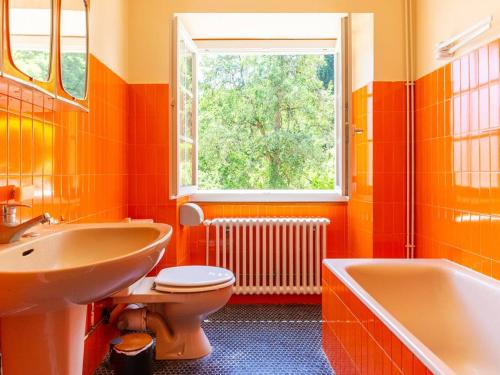 an orange bathroom with a sink and a toilet and a tub at Maison typique 10 pers. avec Wifi, jardin et terrasse, à 5 min de Loudenvielle - FR-1-695-58 in Avajan