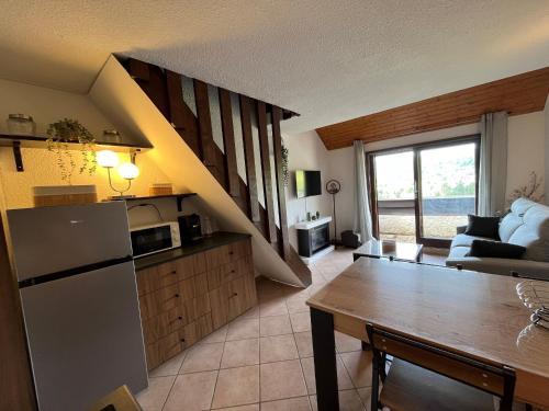Il dispose d'une cuisine et d'un salon avec un réfrigérateur et une table. dans l'établissement Appartement T2 cabine + mezzanine, entièrement refait, à Corrençon en Vercors, proche pistes de ski - FR-1-761-40, à Corrençon-en-Vercors