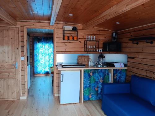 a kitchen with a counter and a blue couch in a room at Séjour unique sur bateau grand confort à Digoin, 6 pers, terrasse, cuisine équipée - API-1-46-26 in Digoin