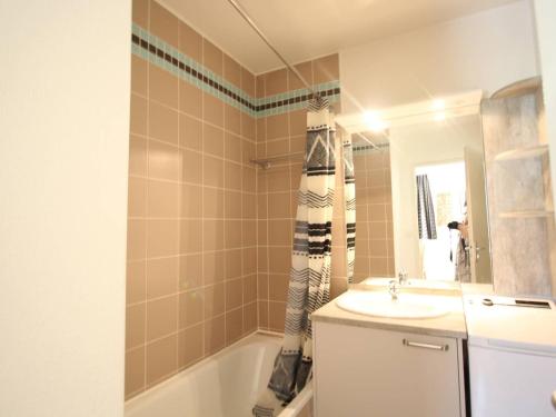 um banheiro com pia, banheira e espelho em Appartement T3 à Luchon: Balcon, Parking, Proche Thermes & Centre, Bien Équipé - FR-1-313-232 em Luchon
