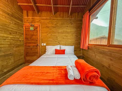 a bedroom with a bed with an orange blanket at Loma Nevada Minca Hotel in Minca