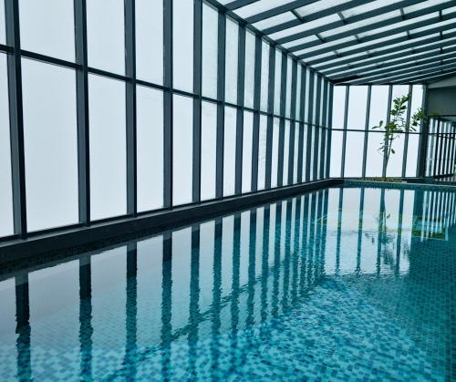 a swimming pool in a building with glass walls at Wyndham Ion Majestic Genting Highlands in Genting Highlands