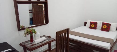 a bedroom with a bed and a mirror at Bee and Birds Hotel in Polonnaruwa