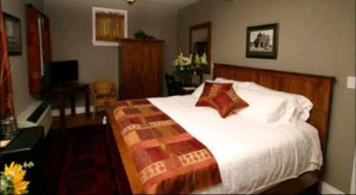 a bedroom with a large bed and a desk at Bayside Inn in Parry Sound