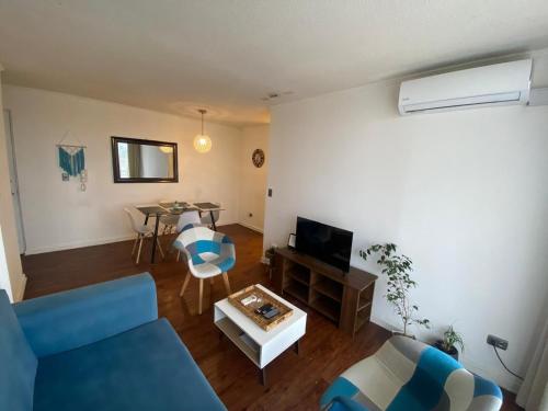 a living room with a blue couch and a table at Apartamento Boldo Curico in Curicó