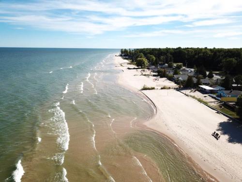 an aerial view of a beach with the ocean at Beach Club of Oscoda - All 4 Beachfront Cottages in Oscoda