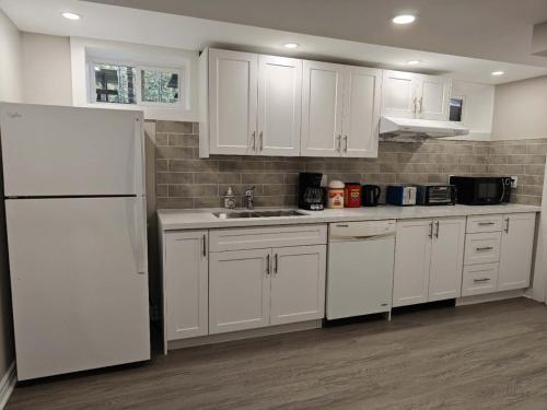 a kitchen with white cabinets and a white refrigerator at Pool House in St. Catharines