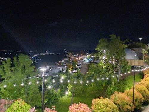 a town with lights on a hill at night at Chill & View ชิววิว เขาค้อ in Ban Huai Phai
