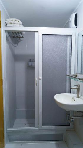 a bathroom with a glass shower and a sink at Lm's Retreat 2BR Condo Unit Marina Spatial in Dumaguete