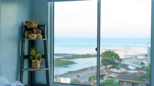 a teddy bear sitting on a shelf next to a window at Lm's Retreat 2BR Condo Unit Marina Spatial in Dumaguete
