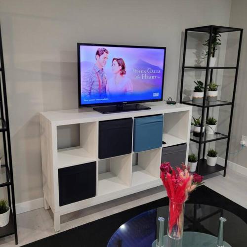 un televisor sentado en la parte superior de un centro de entretenimiento blanco en The Owusu's Villa, en Dieppe