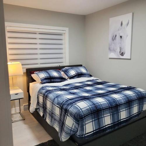 a bedroom with a bed with a blue and white comforter at The Owusu's Villa in Dieppe