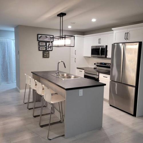 a kitchen with a island with a sink and a refrigerator at The Owusu's Villa in Dieppe