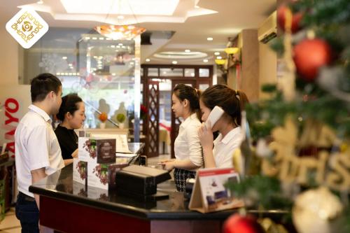 a group of people standing at a counter in a store at Hoa Hong Hotel - Xa Dan in Hanoi