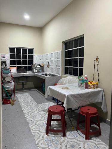 a kitchen with a table and two red stools at Al-Hijrah Homestay Meru Klang in Kapar