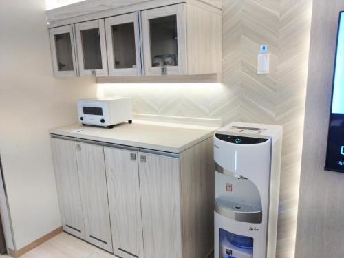a kitchen with a counter with a microwave and a refrigerator at HOTEL The GRAF Matsubara in Miyake