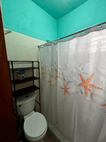 a bathroom with a toilet and a shower curtain with starfish at Casa Flor de Mayo in Santa Cruz Huatulco