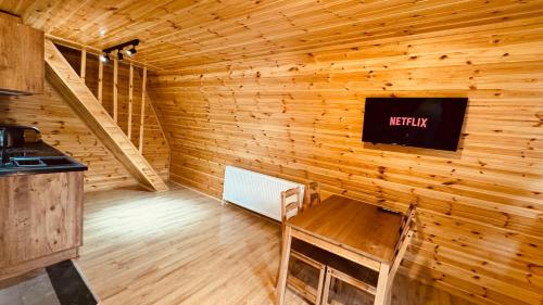 Una habitación con un televisor en una pared de madera. en Kazbegi Milla Cottages&Spa, en Kazbegi