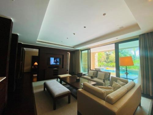 a living room with a couch and a table at Raffles Hainan Clear Water Bay in Sanya