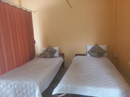 two beds in a room with white sheets at Salika Hostel Patong Phuket in Patong Beach
