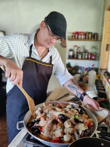 a man in a kitchen preparing food in a pan at Casa de campo vacacional "Tres Soles" en Xico, Veracruz in Xico