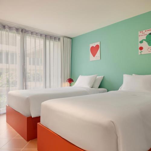 two beds in a room with blue walls at Molly Beach House by Yudee Assets in Hua Hin