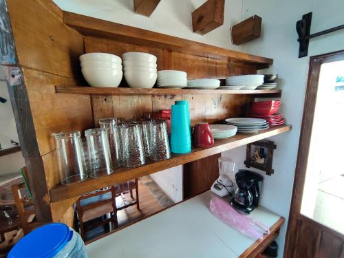 a kitchen with wooden shelves with plates and bowls at Casa de campo vacacional "Tres Soles" en Xico, Veracruz in Xico