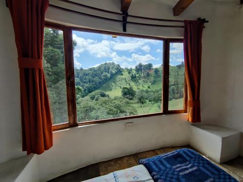 a bedroom with a large window with a view at Casa de campo vacacional "Tres Soles" en Xico, Veracruz in Xico