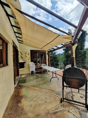 an outdoor patio with a grill and a table at Casa de campo vacacional "Tres Soles" en Xico, Veracruz in Xico