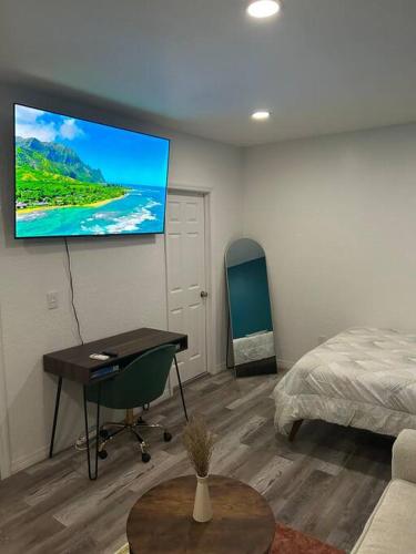 a room with a bed and a desk and a television at Private Studio Suite in Central Orlando With Full kitchen in Orlando