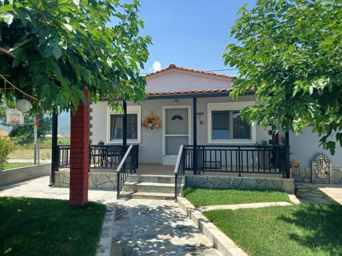 a house with a porch and a tree at Kerkini Houses in Kerkíni