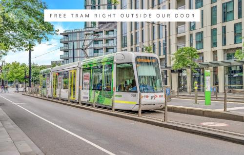 a bus is parked on the side of a street at Melbourne Lifestyle Apartments - Best Views on Collins in Melbourne